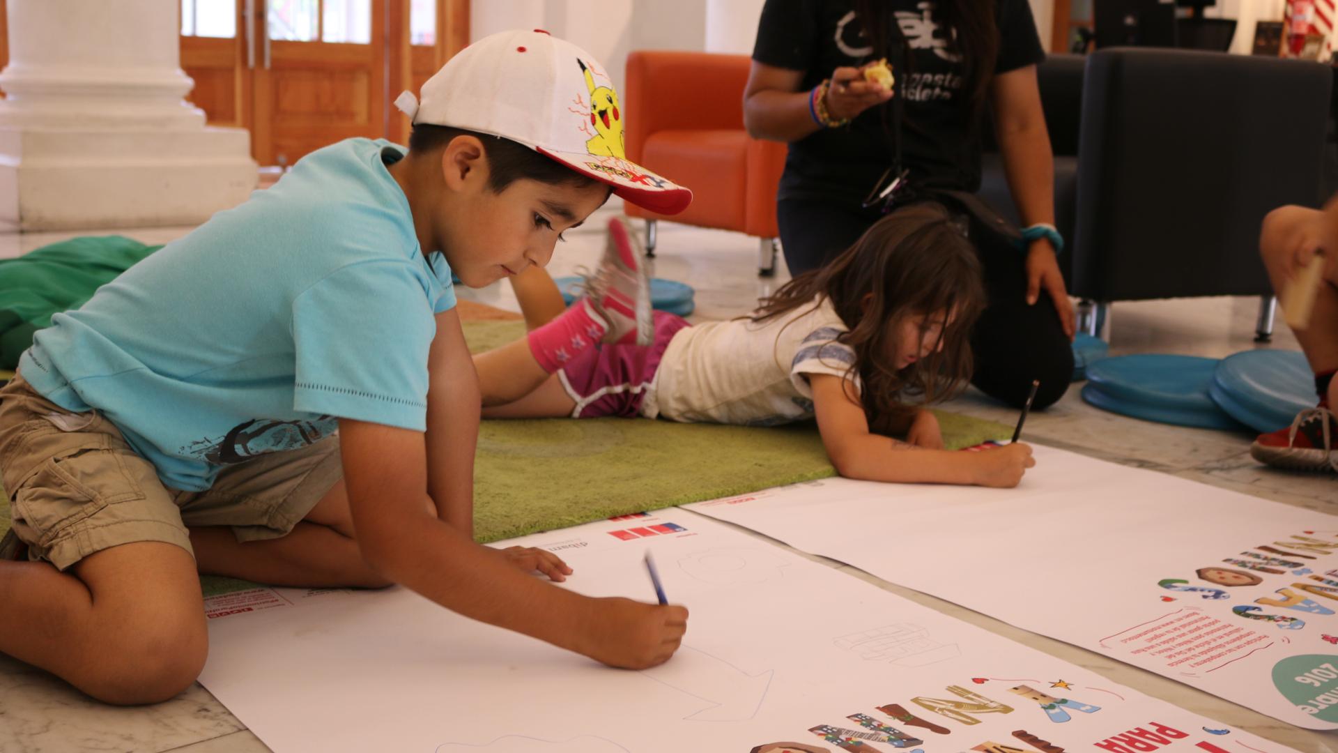 niño y niña escribiendo en un papel blanco en la biblioteca 