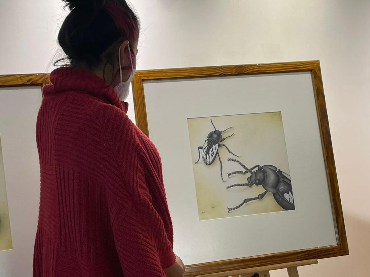 Mujer mirando cuadro de exposición 