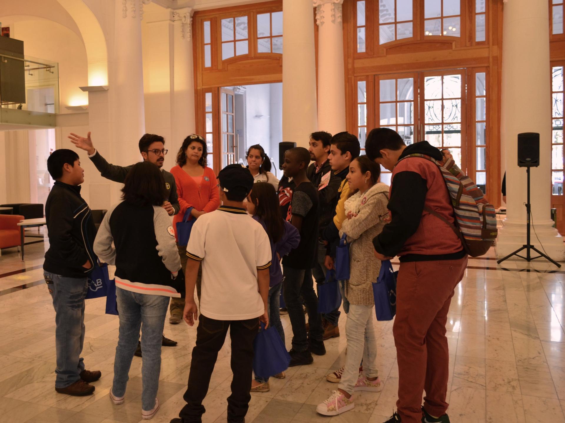 funcionario con usuarios iniciando visita guiada en biblioteca