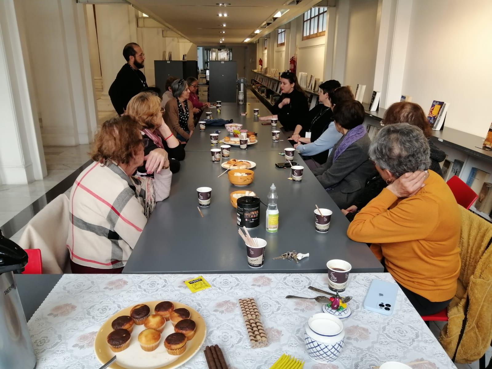 Personas reunidas en torno a una grata conversación en el hall de la biblioteca