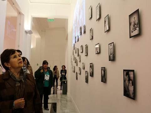 Personas mirando la exposición "Rostros".