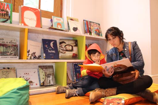 Madre leyendo cuento a hijo en la Sala Infantil de la biblioteca