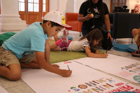 niño y niña escribiendo en un papel blanco en la biblioteca 