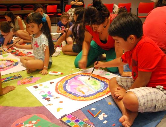 niño con su mamá pintando con acuarela en forma de círculo